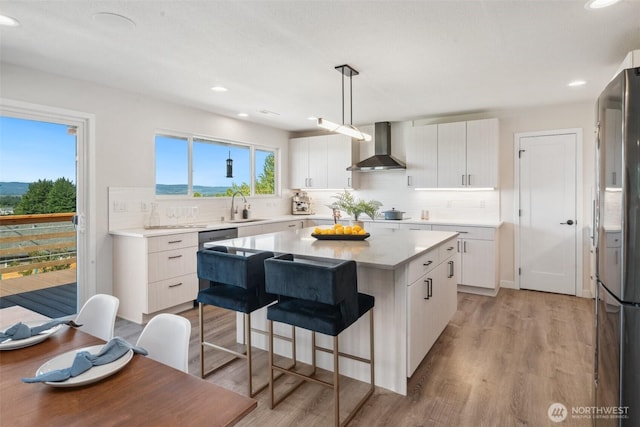 6409 NW 202nd Cir, Ridgefield, WA 98642 - kitchen featuring wall chimney range hood, a sink, freestanding refrigerator, decorative backsplash, and recessed lighting