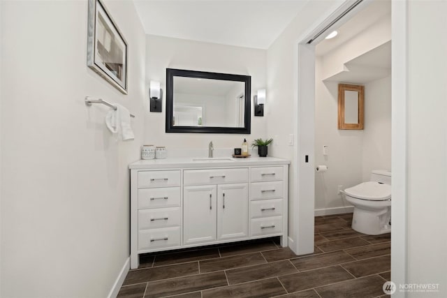 6409 NW 202nd Cir, Ridgefield, WA 98642 - bathroom with vanity, toilet, baseboards, and wood tiled floors