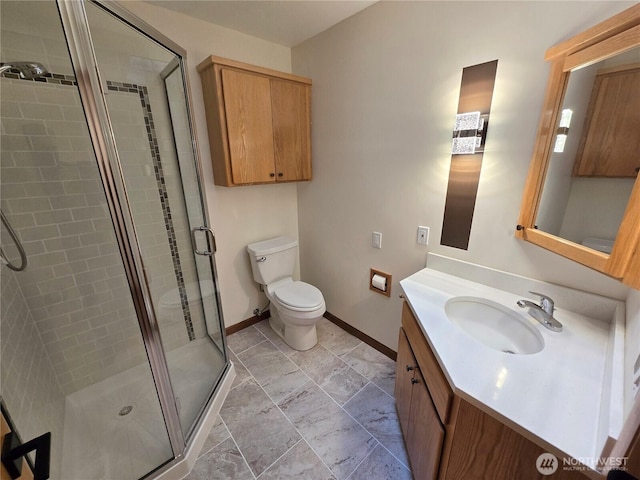 bathroom with vanity, a stall shower, and toilet