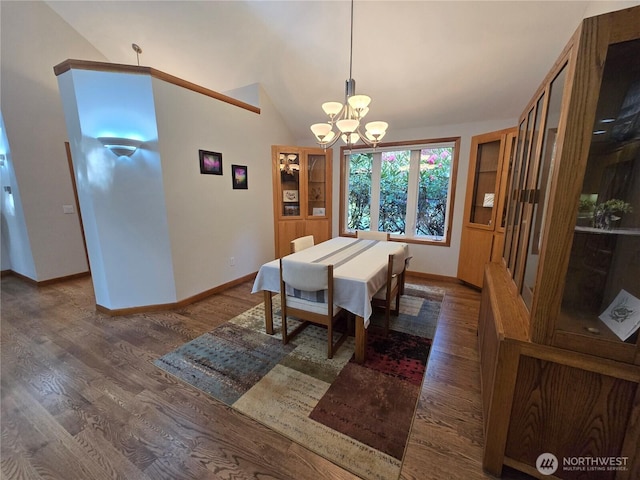 dining space with baseboards, wood finished floors, a notable chandelier, and vaulted ceiling