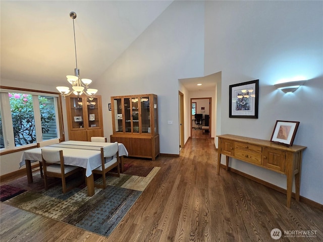 dining area featuring baseboards, wood finished floors, and a chandelier