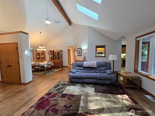 living room with beam ceiling, high vaulted ceiling, baseboards, wood finished floors, and visible vents