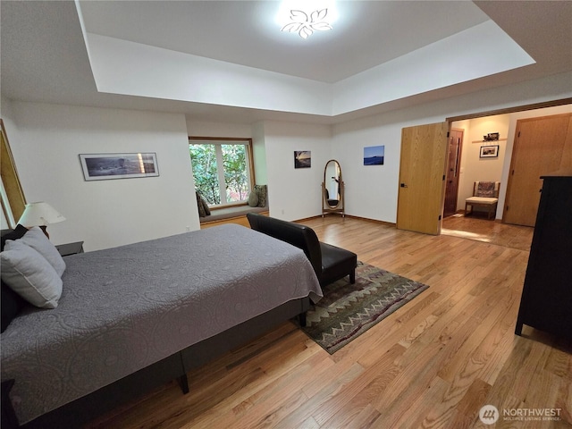bedroom featuring a tray ceiling and wood finished floors