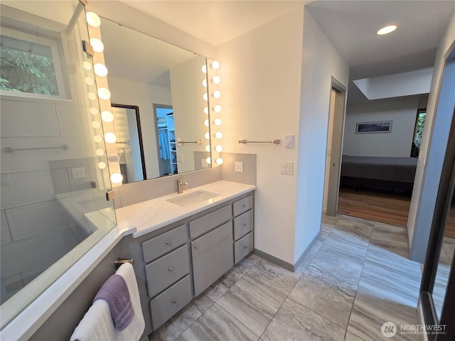 ensuite bathroom featuring vanity, baseboards, ensuite bath, and marble finish floor