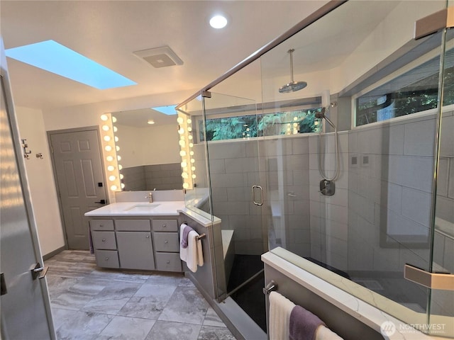 bathroom with vanity, a shower stall, and recessed lighting