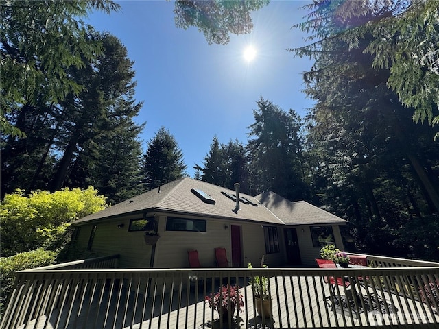 view of front of house featuring a wooden deck and a shingled roof