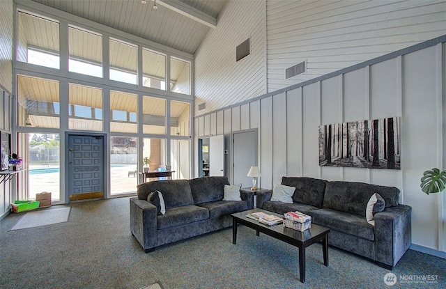 carpeted living area featuring high vaulted ceiling and beam ceiling