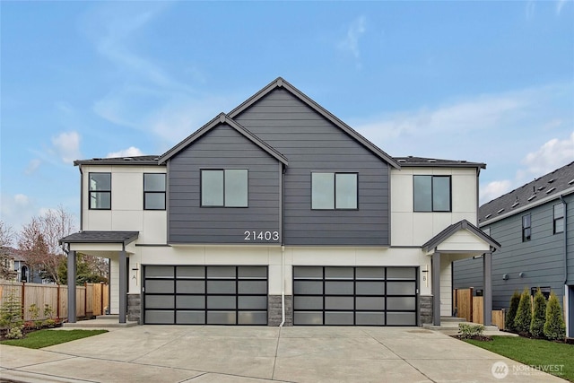 21403 39th Dr SE Unit B, Bothell, WA 98021 - contemporary house featuring fence, an attached garage, concrete driveway, and stone siding