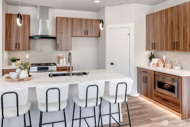 21403 39th Dr SE Unit B, Bothell, WA 98021 - kitchen featuring brown cabinets, wall chimney range hood, a sink, gas range, and a kitchen breakfast bar