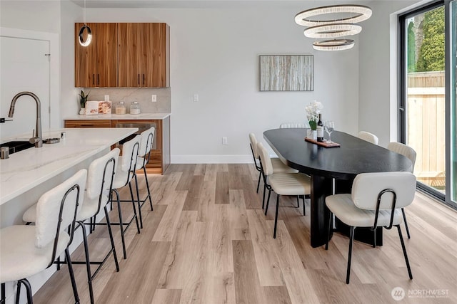 21403 39th Dr SE Unit B, Bothell, WA 98021 - dining space with light wood finished floors, a chandelier, and baseboards