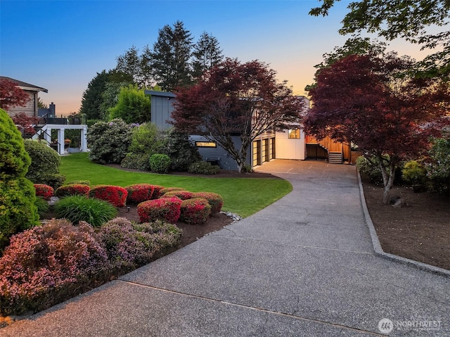 view of front of property with concrete driveway, a front lawn, and a garage