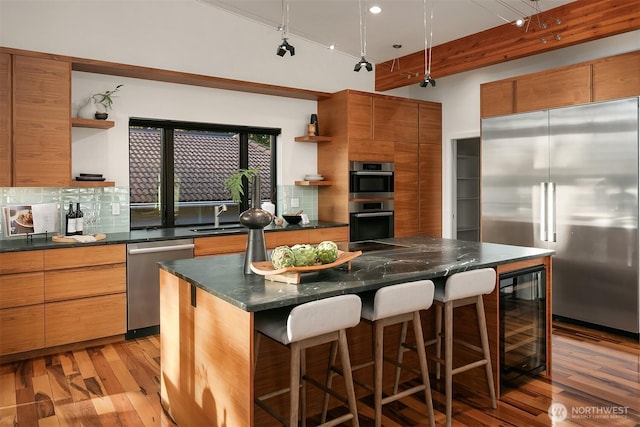 kitchen with open shelves, backsplash, beverage cooler, dark countertops, and appliances with stainless steel finishes