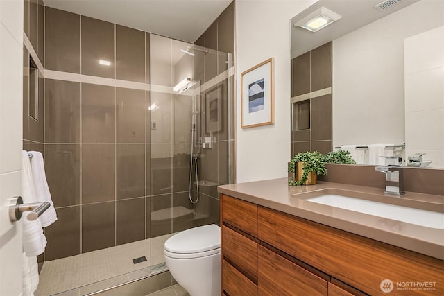 full bathroom featuring toilet, visible vents, a shower stall, tile patterned flooring, and vanity