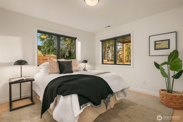 bedroom with baseboards and visible vents