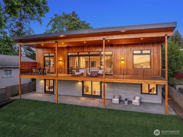 back of property featuring a yard, a patio, and a balcony