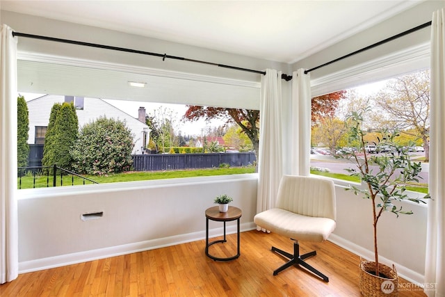 living area featuring baseboards and wood finished floors