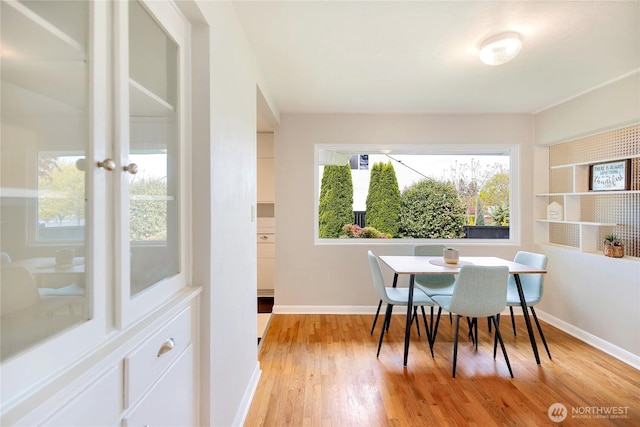 dining area with light wood-style floors and baseboards