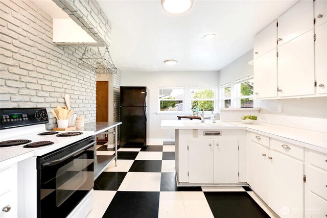 kitchen featuring freestanding refrigerator, light countertops, white cabinets, dark floors, and electric stove