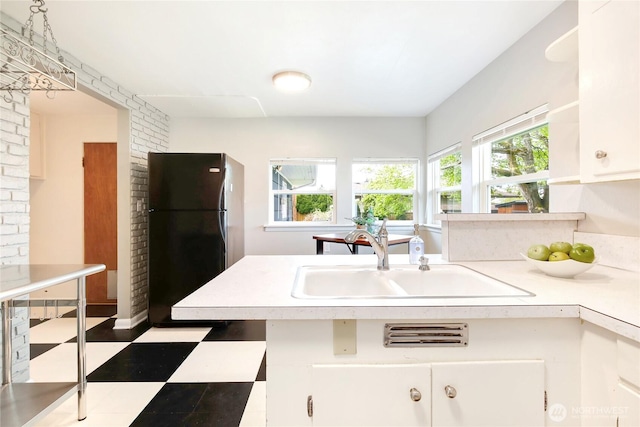 kitchen with open shelves, a sink, tile patterned floors, light countertops, and freestanding refrigerator