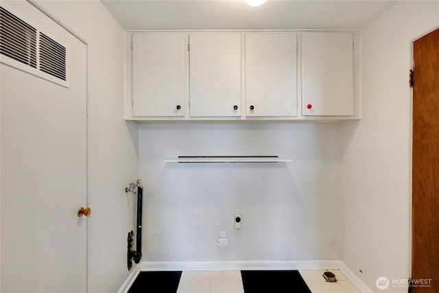 laundry room featuring electric dryer hookup, cabinet space, and baseboards