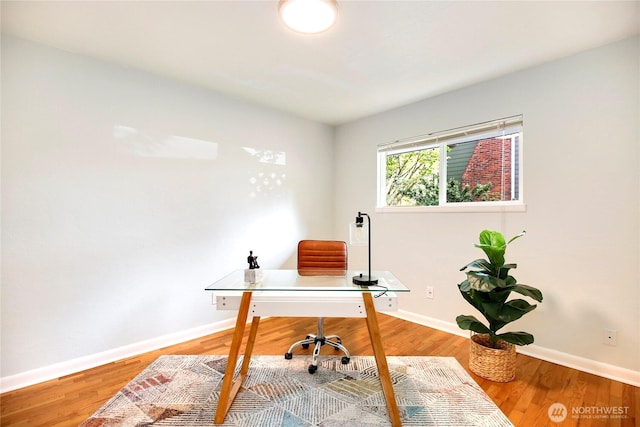 home office featuring baseboards and wood finished floors