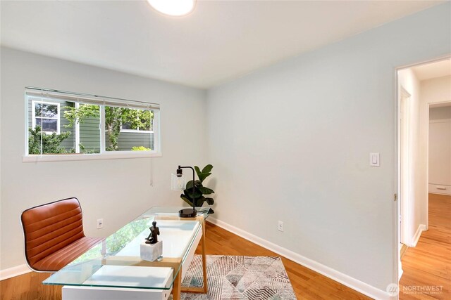 office space featuring baseboards and light wood-style flooring