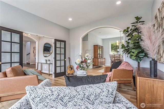 dining space featuring arched walkways, recessed lighting, wood finished floors, and baseboards