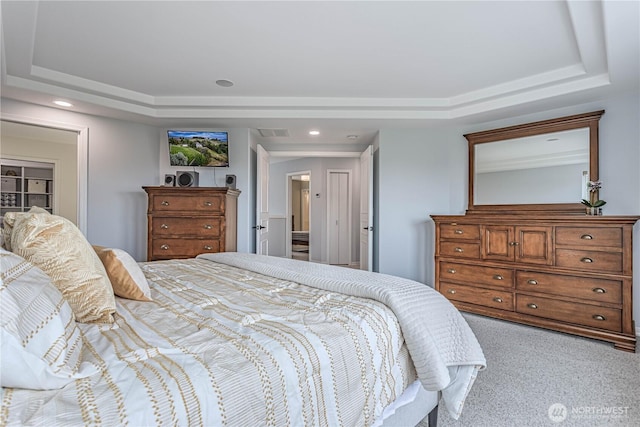 bedroom with a tray ceiling, light colored carpet, and recessed lighting