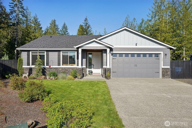 craftsman-style home with fence, a front lawn, stone siding, a garage, and concrete driveway