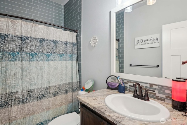bathroom featuring vanity, toilet, curtained shower, and tasteful backsplash