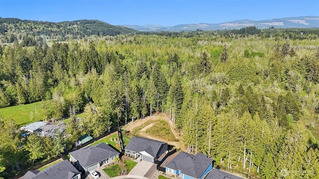 drone / aerial view featuring a mountain view and a wooded view