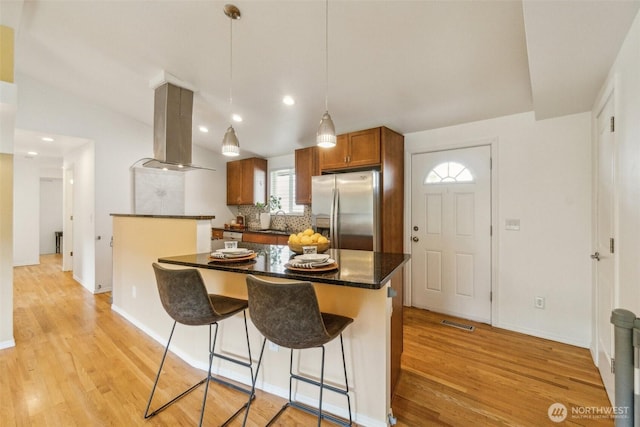 13503 Densmore Ave N, Seattle, WA 98133 - kitchen with stainless steel fridge, island exhaust hood, a sink, light wood-type flooring, and recessed lighting