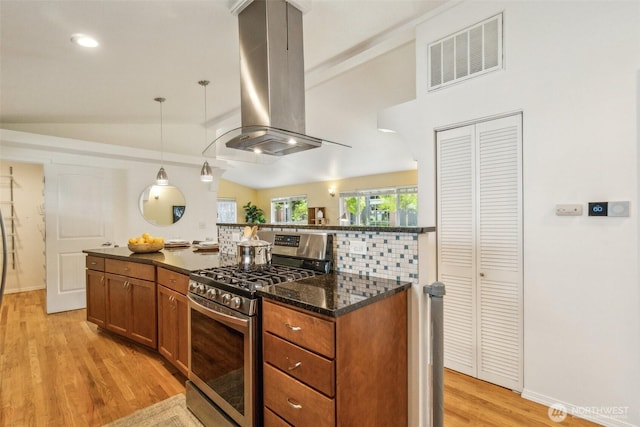 13503 Densmore Ave N, Seattle, WA 98133 - kitchen with gas stove, island range hood, vaulted ceiling, light wood-style floors, and brown cabinetry