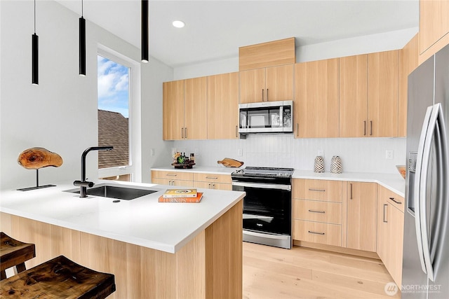 627A W Emerson St, Seattle, WA 98119 - kitchen with light brown cabinetry, appliances with stainless steel finishes, decorative backsplash, and a sink