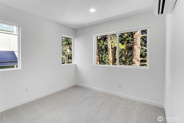 627A W Emerson St, Seattle, WA 98119 - unfurnished room with baseboards, a wall unit AC, a healthy amount of sunlight, and carpet