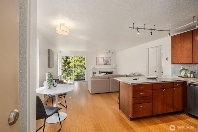 1751 NW 58th St Unit 4, Seattle, WA 98107 - kitchen with tasteful backsplash, a fireplace, light wood-type flooring, track lighting, and a peninsula