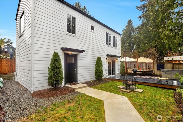 view of front facade featuring fence, outdoor lounge area, a deck, and a front yard