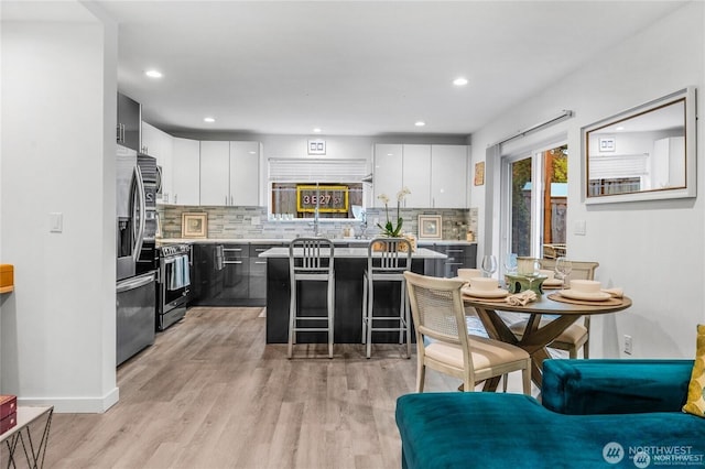 kitchen featuring white cabinets, stainless steel appliances, and tasteful backsplash