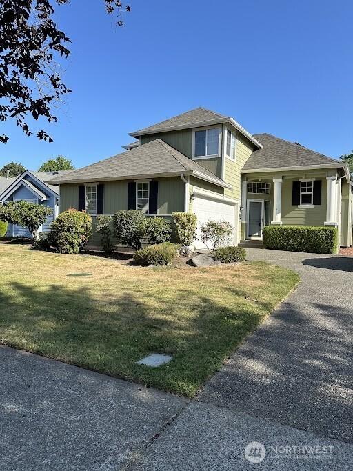 view of front facade with a garage, driveway, and a front lawn