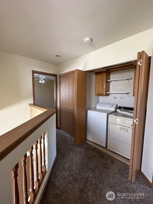 washroom featuring cabinet space, separate washer and dryer, and dark carpet