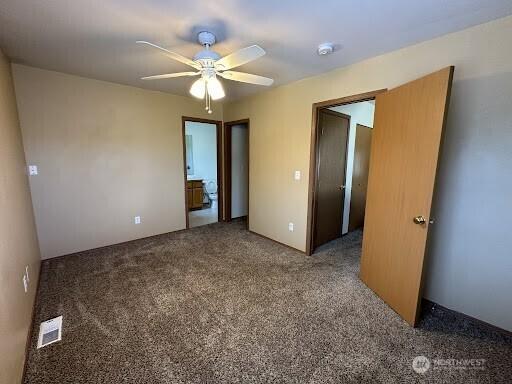 spare room featuring visible vents, a ceiling fan, and carpet floors