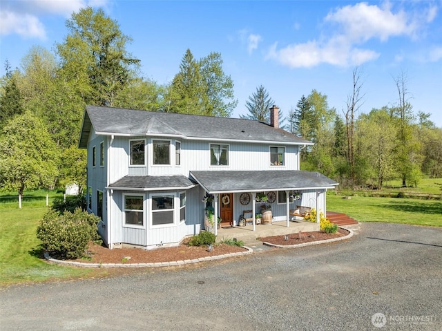 584 Gish Rd, Onalaska, WA 98570 - view of front of home featuring a porch, driveway, a chimney, a front yard, and roof with shingles