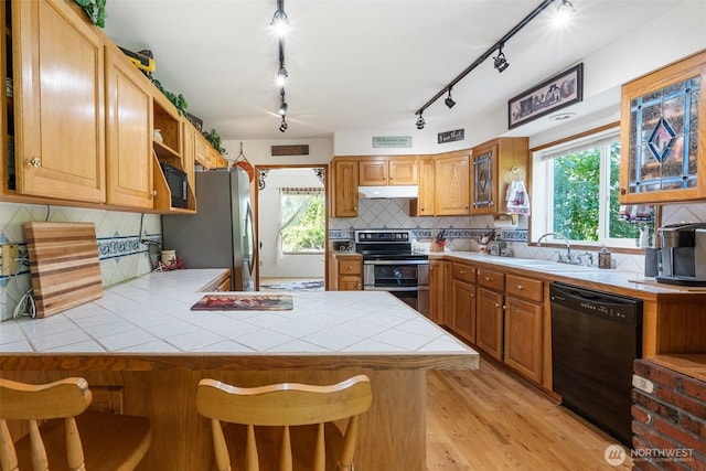 584 Gish Rd, Onalaska, WA 98570 - kitchen featuring tile countertops, a sink, a peninsula, under cabinet range hood, and stainless steel appliances