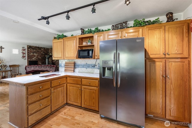 584 Gish Rd, Onalaska, WA 98570 - kitchen with a peninsula, black microwave, tile countertops, stainless steel fridge with ice dispenser, and rail lighting