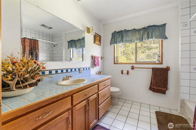 584 Gish Rd, Onalaska, WA 98570 - full bathroom with a healthy amount of sunlight, vanity, tile patterned flooring, and toilet