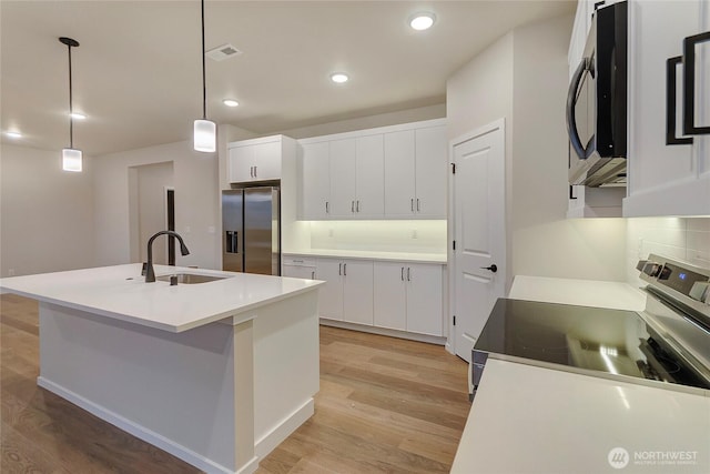 18214 37th Ave E, Tacoma, WA 98446 - kitchen featuring light wood-type flooring, a sink, white cabinetry, and stainless steel appliances