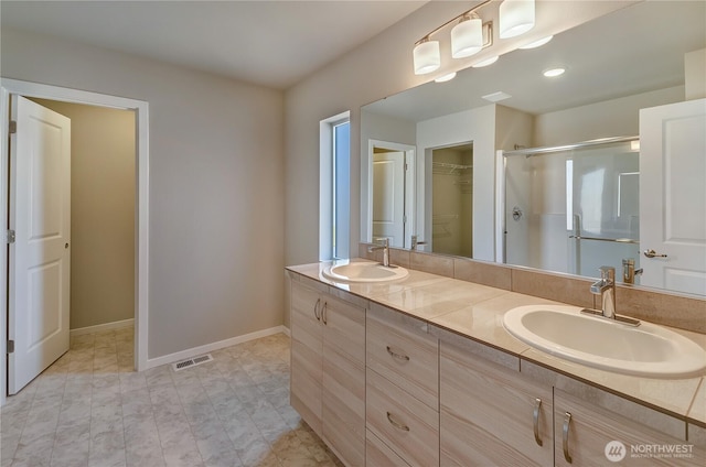 18214 37th Ave E, Tacoma, WA 98446 - full bathroom with visible vents, a sink, a walk in closet, and a shower stall