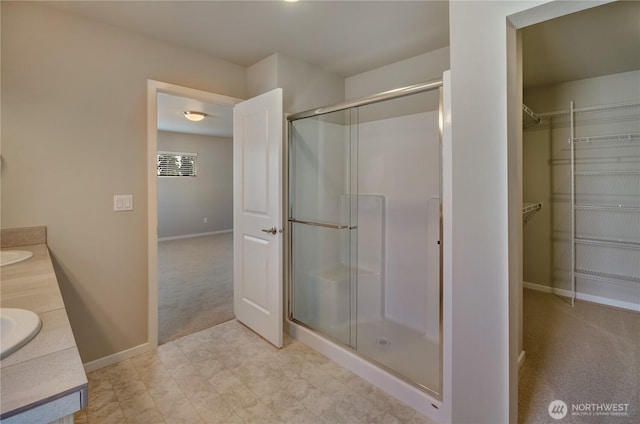 18214 37th Ave E, Tacoma, WA 98446 - bathroom with a sink, double vanity, baseboards, a shower stall, and a spacious closet