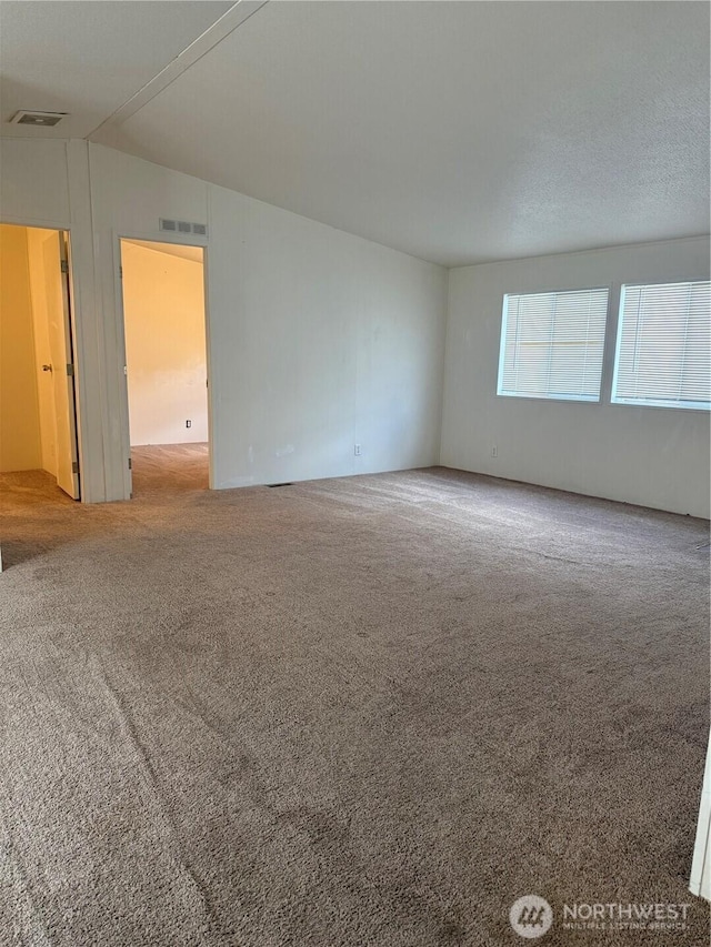 spare room featuring carpet floors and visible vents