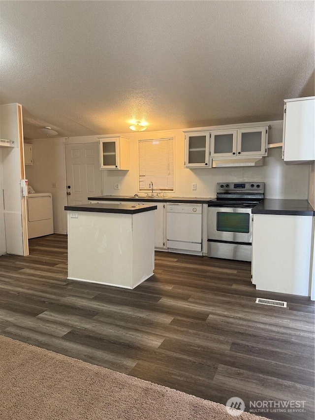 kitchen featuring stainless steel range with electric stovetop, dark countertops, washer / clothes dryer, under cabinet range hood, and dishwasher
